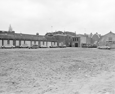 884603 Gezicht op een braakliggend terrein waar huizen gesloopt zijn aan de Jeremiestraat te Utrecht; het rijtje ...